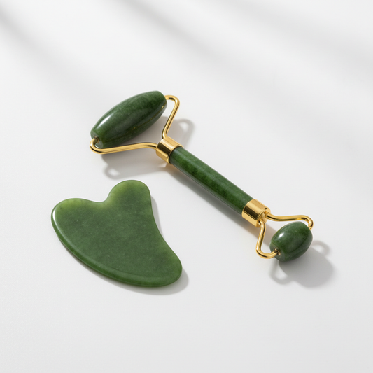 Green jade roller and gua sha facial massage tool set on white background